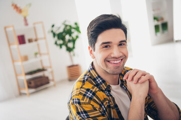 Photo of dreamy positive man wear checkered shirt staying home smiling arms chin indoors house...