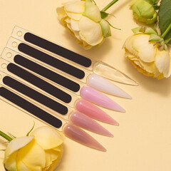 Colorful nail polish palette on yellow background with flowers