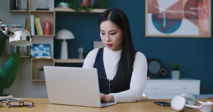 Creating successful career. Satisfied girl getting offer of dream job. Reading message of great opportunity on laptop. Raising her hand in joy and smiling. Exciting from positive moment.