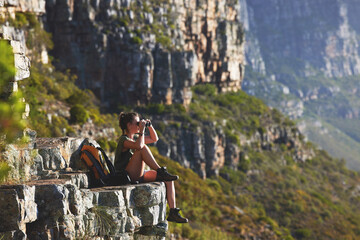 Mountain, woman and hiking for fitness with binoculars on cliff to relax for explore, journey and...