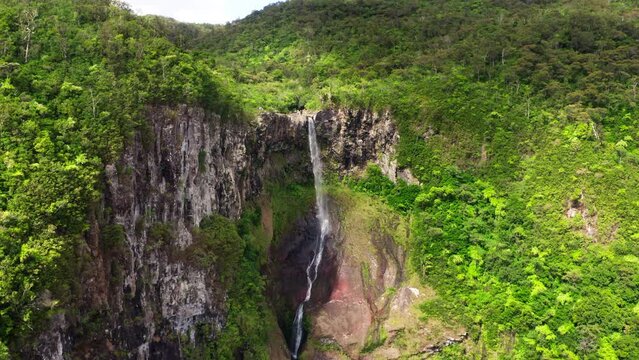 Picturesque flying over the mountain creek fall down from steep high cliff to wide green jungle valley. Cascade 500 Pieds waterfall also known as Cascade des Galets on Mauricius island in Indian ocean