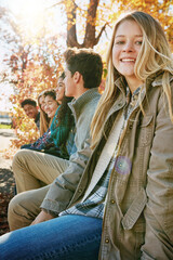 Nature, portrait and group of teenagers on vacation, adventure or weekend trip together in Autumn. Smile, travel and young friends on holiday sitting in outdoor garden, park or field in New Zealand.