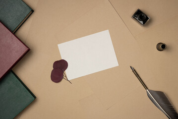 Empty white paper list with quill pen, ink, books on sheets of paper background from above....