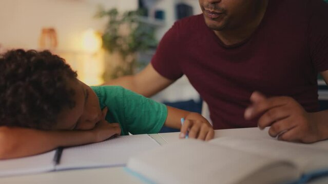 Kind African American father motivates son to do homework, addressing laziness