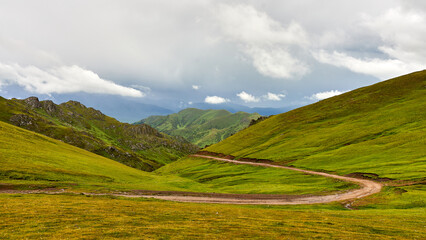 View from the pass to the mountain road and storm clouds