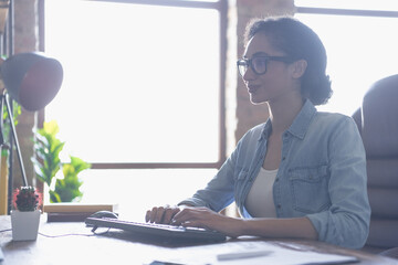 Portrait of young girl it specialist write email keyboard loft interior business center indoors