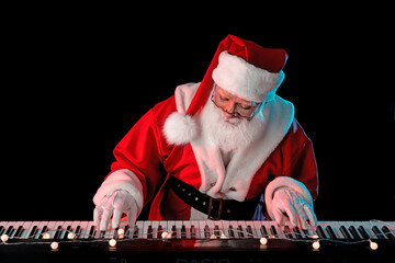 Santa Claus playing the electric piano in a nightclub at a Christmas and New Year party or...