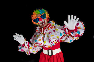 Funny clown in the circus, man entertainer as Joker in a suit and wig, with clown whiteface makeup....