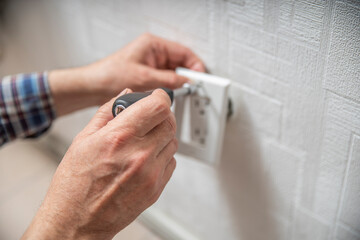 Installation or repair of electrical outlet socket box within the wall. Serviceman or repairman...