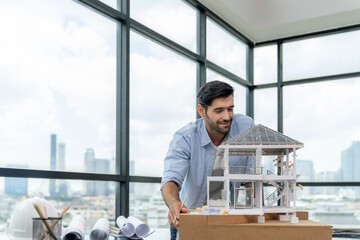 Professional caucasian architect engineer inspect modern house model with skyscraper view while...