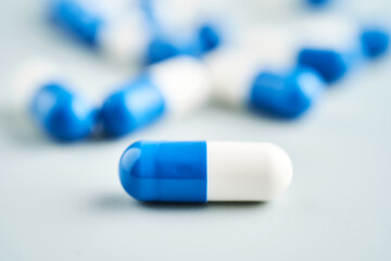 Blue and white capsules on a blue background.