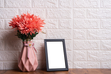 Photo frame mockup image, Beautiful black textured photo frame on a wooden table with flower pot, Blank photo frame background
