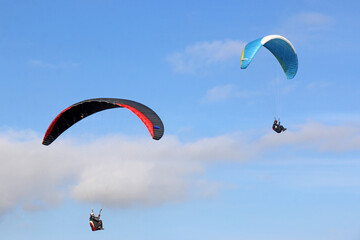 Paragliders flying in a blue sky	
