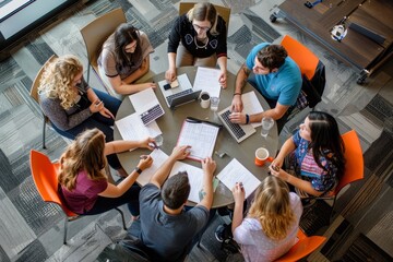 A group of individuals sitting around a table, focused on laptops, working and collaborating, A group of students collaborating at a round table