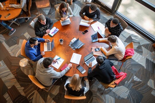 A group of students collaborating and discussing around a wooden table, A group of students collaborating at a round table