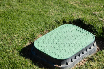 Valve box cover in green grass