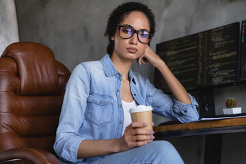 Portrait of young girl it specialist serious face drink coffee loft interior business center indoors