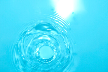The water surface is clear blue with circular waves.