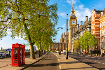 Red telephone boxes on Victoria embankment and Big Ben tower, London, UK