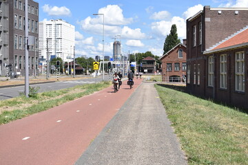 Fototapeta premium Dynamic Urban Scene: Street View with Bicycle Lane, Cyclists, and Traffic Flow - Embracing Sustainable Mobility Amidst City Life