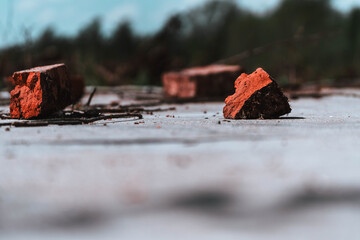Broken red brick on a wooden floor. Selective focus.