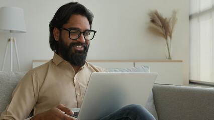 Arabian muslim man freelancer working from home focused millennial guy indian businessman typing on...