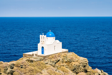 View of small church built on rocks and blue sea in background in Kastro village, Sifnos island,...