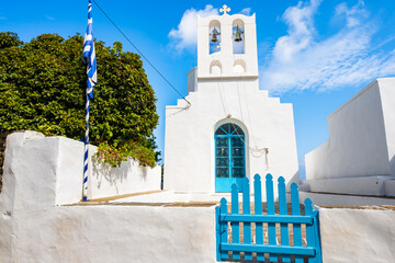 Front view of traditional style white church with blue entrance gate in Artemonas village, Sifnos...