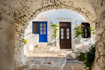 Stone arch and view of houses on narrow street of Kastro traditional Greek village, Sifnos island,...