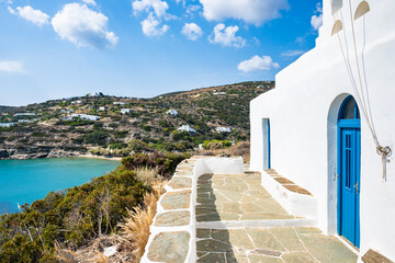 White church on coastal walking path to Marina Gialos bay beach, Sifnos island, Greece