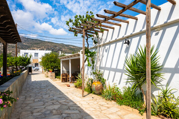 Beautiful architecture of Platis Gialos village with colorful flowers in pots near beach, Sifnos...