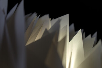 pieces of white folded paper on black background