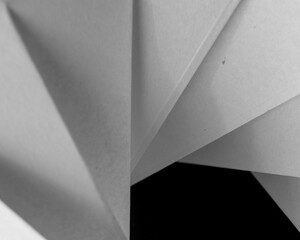 pieces of white folded paper on black background