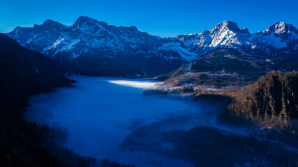 Dawn over Almsee in Upper Austria, Misty Valley with Snow-Covered Peaks and Frozen Lake