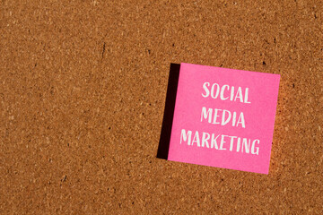 Social media marketing words written on pink paper sticker with brown background. Conceptual social...