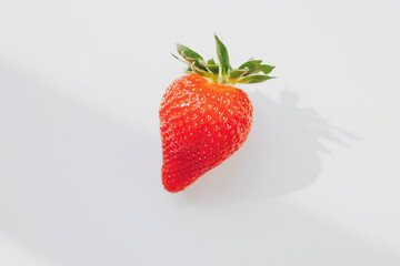 strawberry on a white background with sharp shadows. Minimum summer concept. 