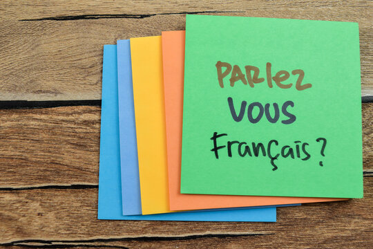 Concept of Parlez Vous Francais in Language Germany write on sticky notes isolated on Wooden Table.