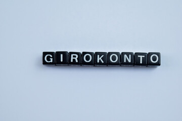 Concept of Girokonto written on wooden blocks. Cross processed image on Wooden Background