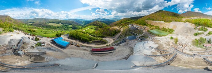 Carpathian Mountains of Ukraine, a quarry where granite sandstone is mined for the production of building materials, powerful trucks and conveyors load gravel - video from a drone