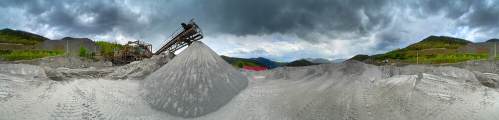 Carpathian Mountains of Ukraine, a quarry where granite sandstone is mined for the production of building materials, powerful trucks and conveyors load gravel - video from a drone