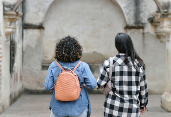 Mujeres jóvenes bonitas de viaje por Antigua Guatemala, caminando en unas de las ruinas de la...