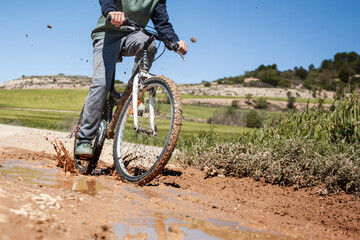 A boy is riding a bike on a muddy road