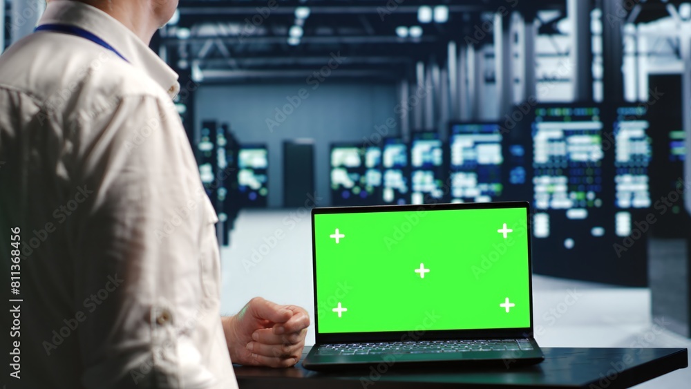 Poster programmer in server room expertly managing data while navigating through industrial rackmounts. wor