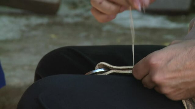An Argentine Gaucho Repairing Horse Bridles in his Country House. Close Up.