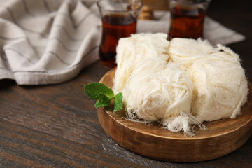 Eastern sweets. Tasty Iranian pashmak on wooden table, closeup. Space for text