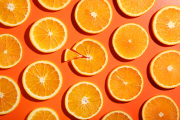 Slices of juicy orange on terracotta background, flat lay