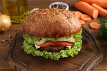 Delicious vegetarian burger served on wooden table, closeup