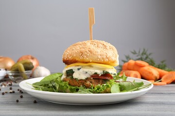 Delicious vegetarian burger served on grey wooden table