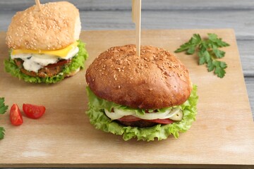 Delicious vegetarian burgers served on grey wooden table