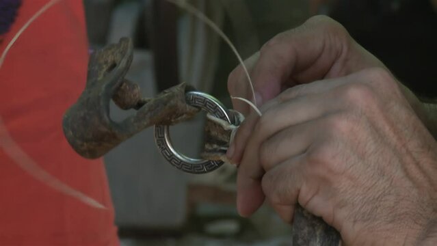 An Argentine Gaucho Repairing Horse Bridles in his Country House. Close Up.
